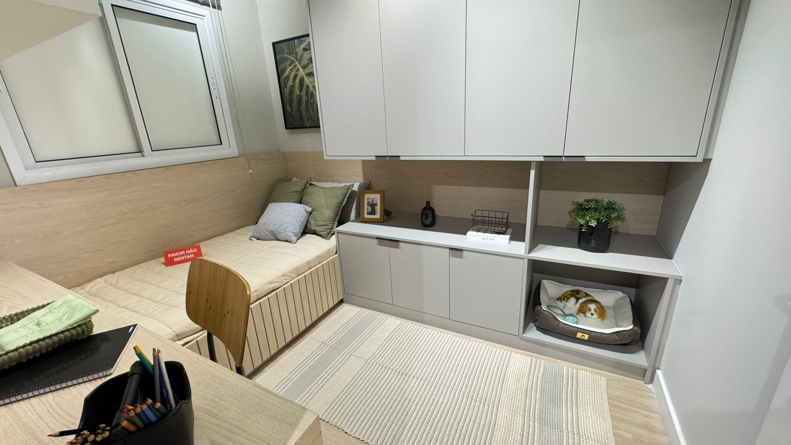 Área de serviço compacta integrada à cozinha de apartamento, com armários claros e máquina de lavar embutida
